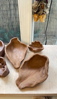 four clay bowls sitting on a window sill
