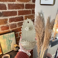 a person is holding a ceramic planter with an eye on it